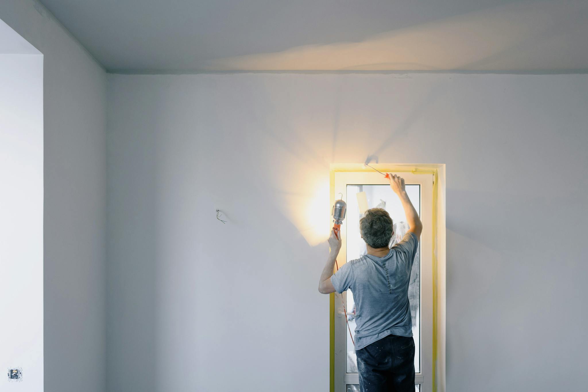 About A Handyman Works On A Home Renovation Project Painting A Door Indoors. 5691693 2048x1367