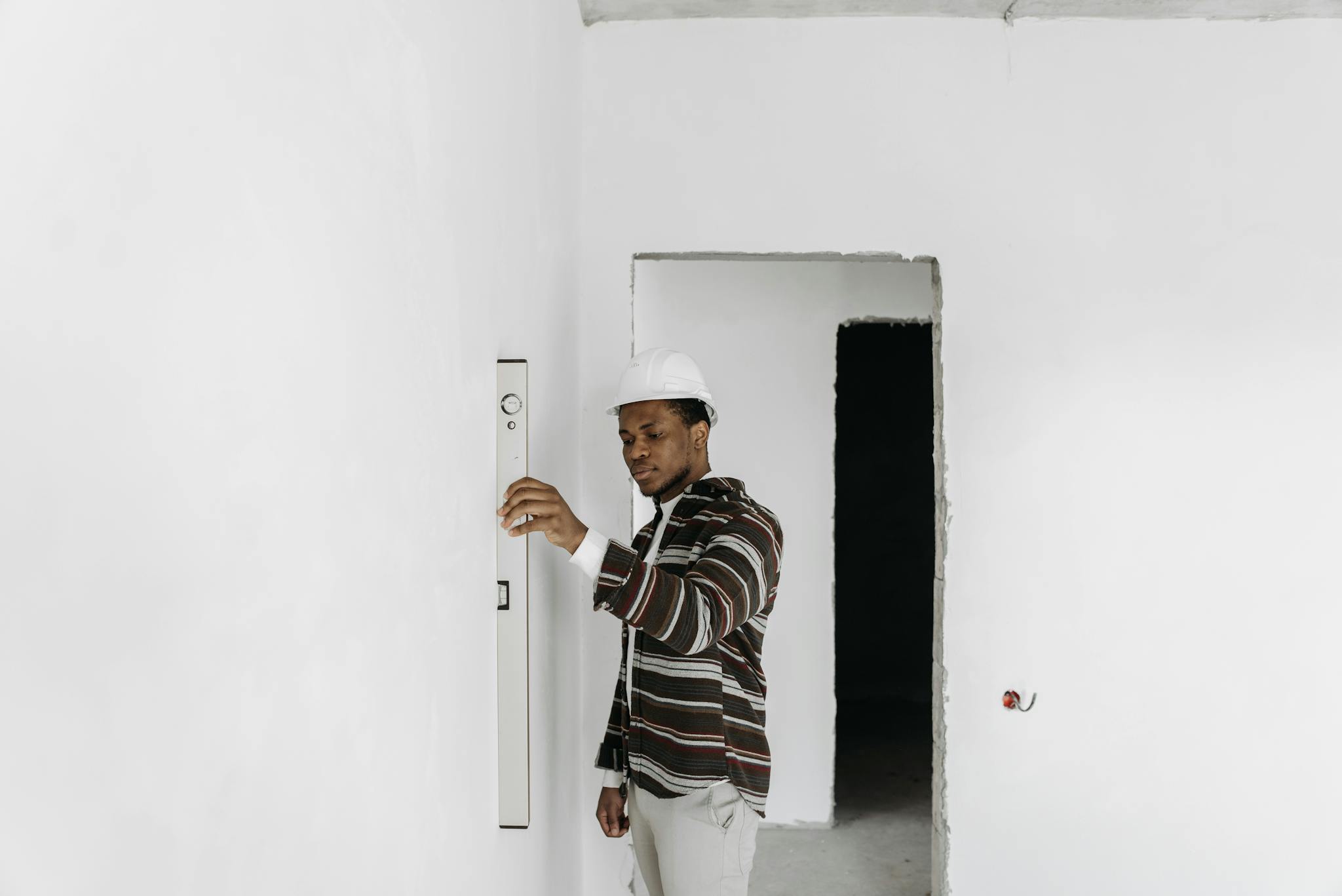 Gallery Architect Wearing Hard Hat Checks Wall Alignment In A Renovation Project. 7937963 2048x1367